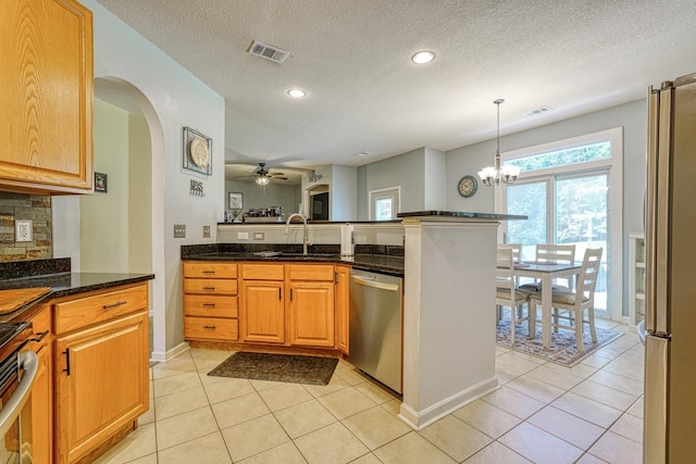 316 Crestview Ln, Spartanburg, SC 29301 - kitchen with appliances with stainless steel finishes, a peninsula, ceiling fan, arched walkways, and a chandelier