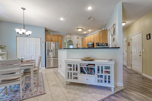 316 Crestview Ln, Spartanburg, SC 29301 - kitchen with stainless steel appliances, a chandelier, a textured ceiling, dark countertops, and pendant lighting