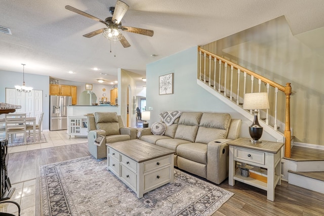 316 Crestview Ln, Spartanburg, SC 29301 - living room with stairway, a ceiling fan, a chandelier, a textured ceiling, and light wood-style floors