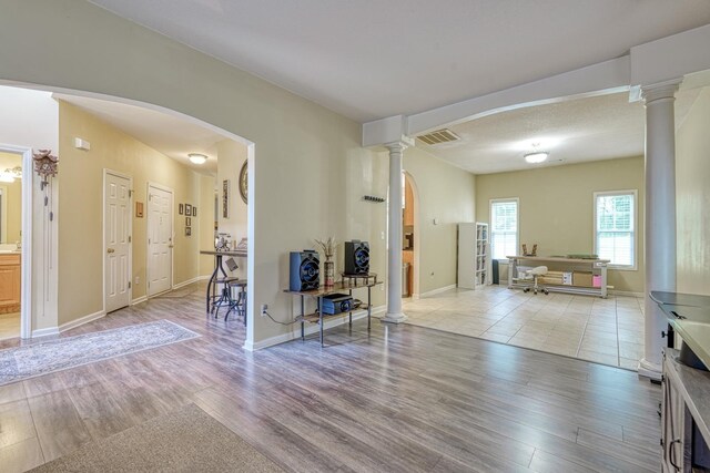 316 Crestview Ln, Spartanburg, SC 29301 - living room with light wood-style flooring, arched walkways, and decorative columns