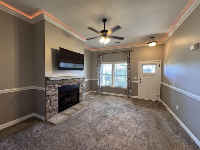 313 Trail Crossing Ln, Inmann, SC 29349 - unfurnished living room with carpet flooring, ceiling fan, a stone fireplace, a textured ceiling, and ornamental molding