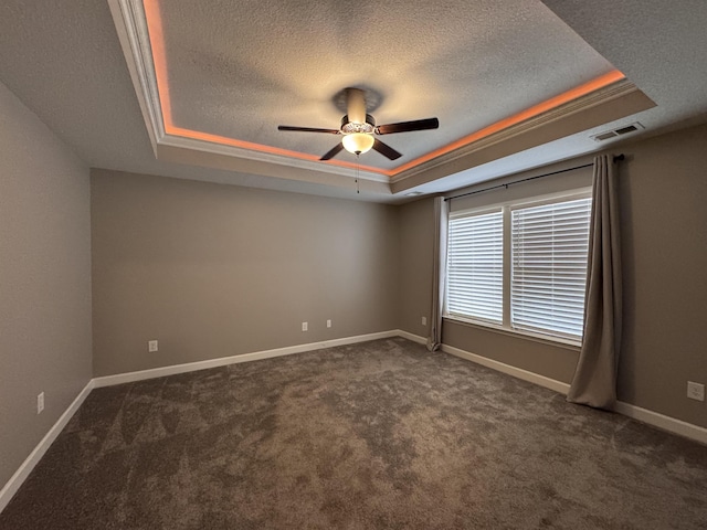 313 Trail Crossing Ln, Inmann, SC 29349 - spare room featuring a tray ceiling, a textured ceiling, dark colored carpet, and a ceiling fan