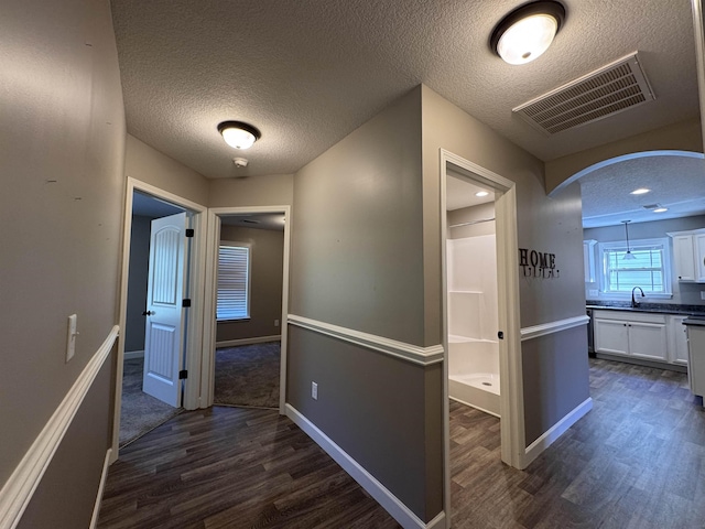 313 Trail Crossing Ln, Inmann, SC 29349 - hallway with a textured ceiling, dark wood-type flooring, and arched walkways