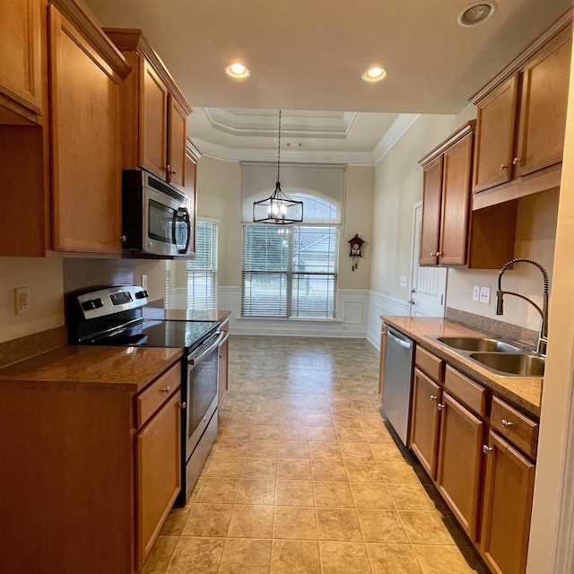 240 Stonecrest Dr, Roebuck, SC 29376 - kitchen featuring stainless steel appliances, a raised ceiling, a decorative wall, crown molding, and brown cabinets