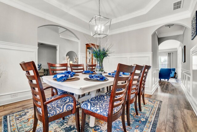 332 Heritage Point Dr, Simpsonville, SC 29681 - dining space with arched walkways, a chandelier, hardwood / wood-style flooring, a decorative wall, and a wainscoted wall