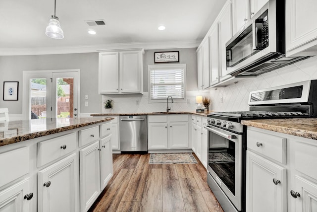 332 Heritage Point Dr, Simpsonville, SC 29681 - kitchen with appliances with stainless steel finishes, ornamental molding, light wood-style floors, white cabinets, and healthy amount of natural light