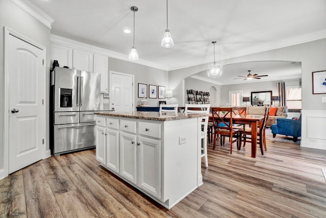 332 Heritage Point Dr, Simpsonville, SC 29681 - kitchen with stainless steel fridge with ice dispenser, arched walkways, ornamental molding, a center island, and a ceiling fan