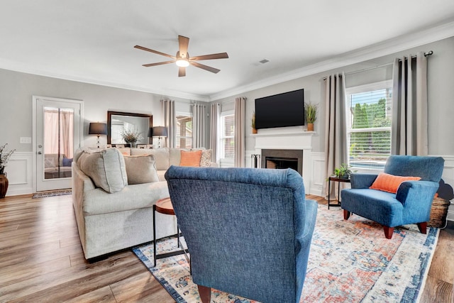 332 Heritage Point Dr, Simpsonville, SC 29681 - living area with ornamental molding, wood finished floors, ceiling fan, a fireplace, and a wainscoted wall