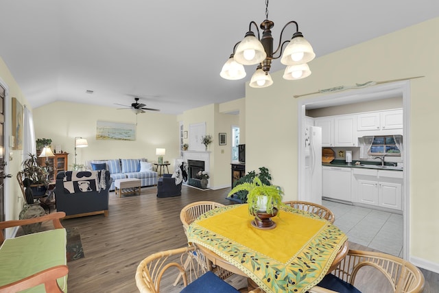 360 W Pointe Dr, Spartanburg, SC 29301 - dining area featuring ceiling fan, a chandelier, a fireplace, vaulted ceiling, and light wood finished floors