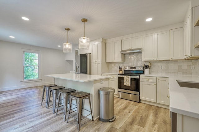 236 Heathwood Dr, Spartanburg, SC 29307 - kitchen with appliances with stainless steel finishes, under cabinet range hood, a breakfast bar area, light wood-style floors, and a center island