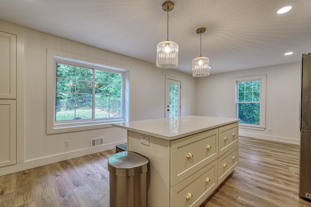 236 Heathwood Dr, Spartanburg, SC 29307 - kitchen with light wood-style floors, light countertops, pendant lighting, a center island, and freestanding refrigerator