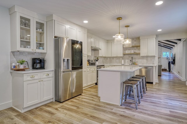 236 Heathwood Dr, Spartanburg, SC 29307 - kitchen featuring stainless steel appliances, under cabinet range hood, a breakfast bar area, light countertops, and white cabinets