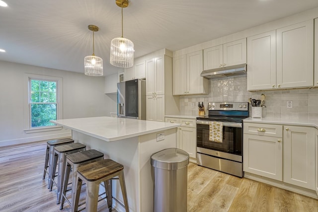 236 Heathwood Dr, Spartanburg, SC 29307 - kitchen featuring stainless steel appliances, under cabinet range hood, a kitchen breakfast bar, light wood-type flooring, and light countertops