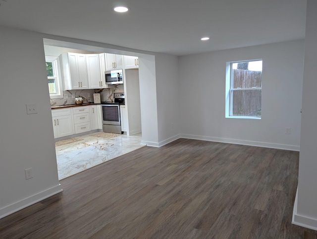 2115 Oakhurst Cir, Spartanburg, SC 29302 - kitchen with appliances with stainless steel finishes, dark countertops, wood finished floors, white cabinetry, and recessed lighting