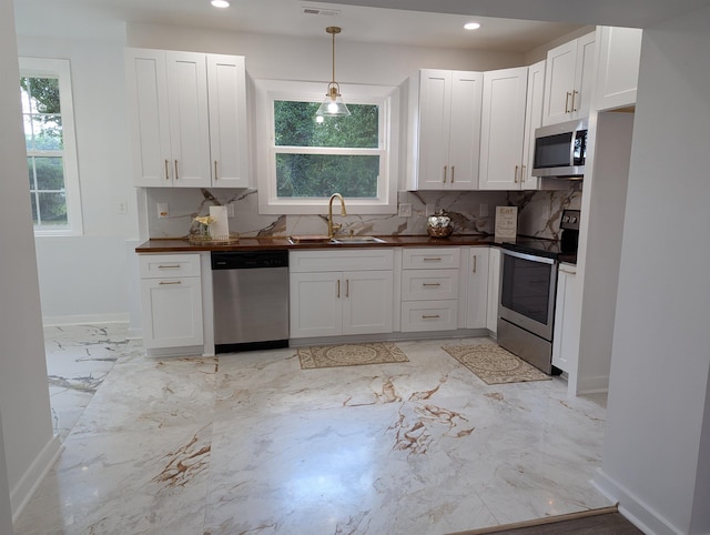 2115 Oakhurst Cir, Spartanburg, SC 29302 - kitchen with appliances with stainless steel finishes, white cabinetry, decorative backsplash, light marble finish flooring, and recessed lighting
