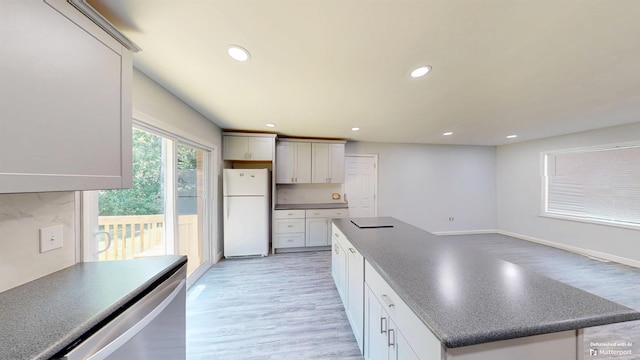 136 Sparkstown Dr, Enoree, SC 29335 - kitchen with freestanding refrigerator, light wood-style flooring, dark countertops, recessed lighting, and a kitchen island