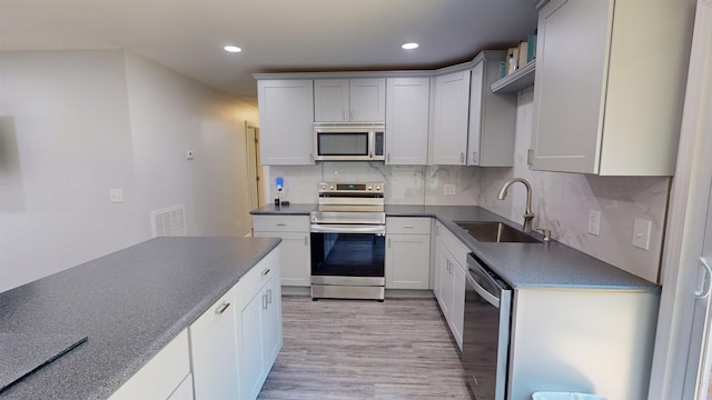 136 Sparkstown Dr, Enoree, SC 29335 - kitchen with stainless steel appliances, dark countertops, light wood finished floors, tasteful backsplash, and recessed lighting