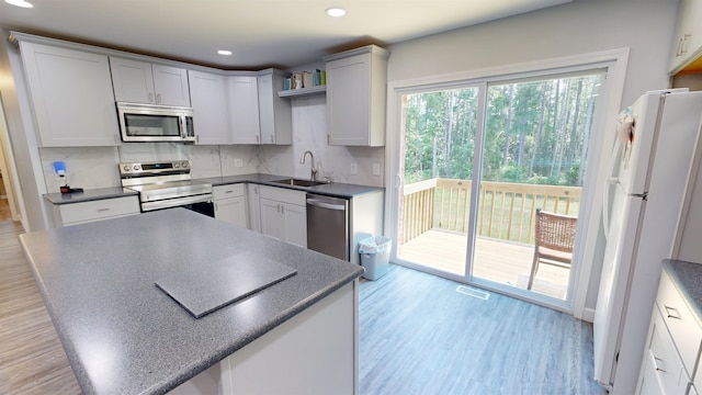 136 Sparkstown Dr, Enoree, SC 29335 - kitchen featuring stainless steel appliances, backsplash, dark countertops, light wood-style floors, and recessed lighting