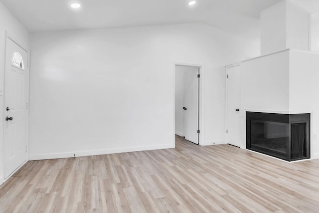 339 Crestview Dr, Spartanburg, SC 29306 - unfurnished living room featuring light wood-type flooring, a multi sided fireplace, recessed lighting, and lofted ceiling