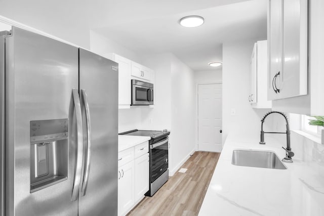 339 Crestview Dr, Spartanburg, SC 29306 - kitchen with stainless steel appliances, white cabinetry, light wood finished floors, and light stone countertops