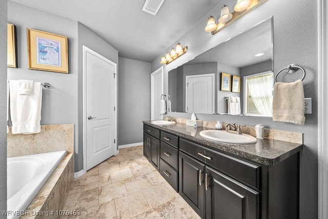 bathroom with vanity and tiled bath