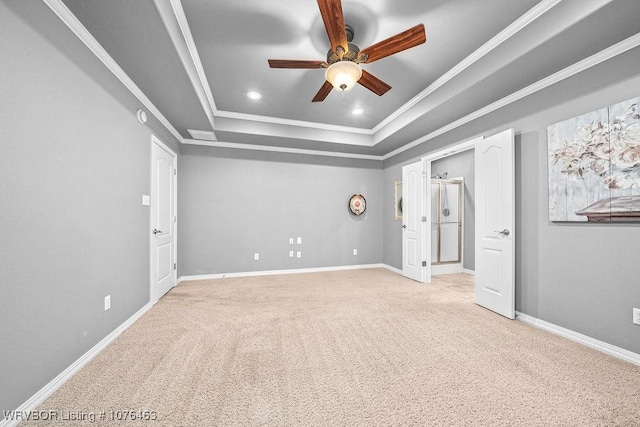 unfurnished bedroom featuring a raised ceiling, ceiling fan, crown molding, and light carpet