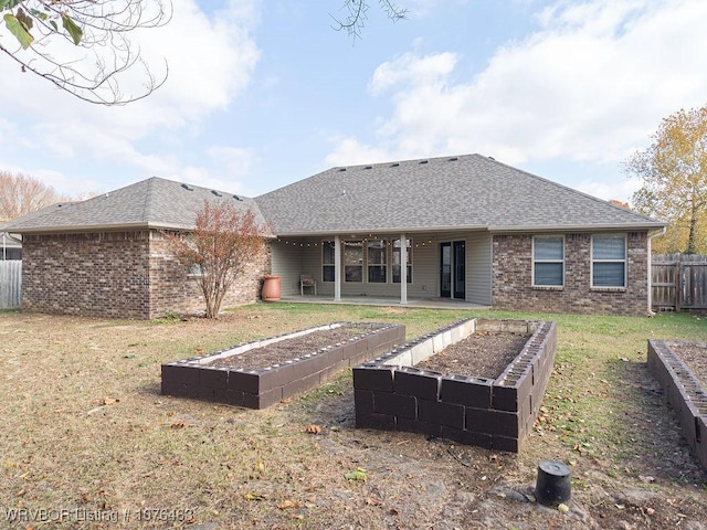 rear view of property with a yard and a patio area