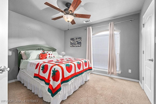 carpeted bedroom with ceiling fan and a textured ceiling