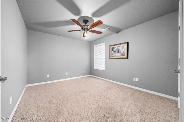 carpeted empty room with a textured ceiling and ceiling fan