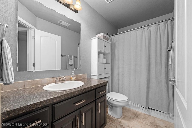 bathroom with tile patterned flooring, vanity, and toilet