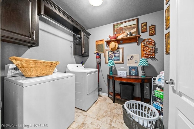 laundry room with washer and dryer, cabinets, and a textured ceiling