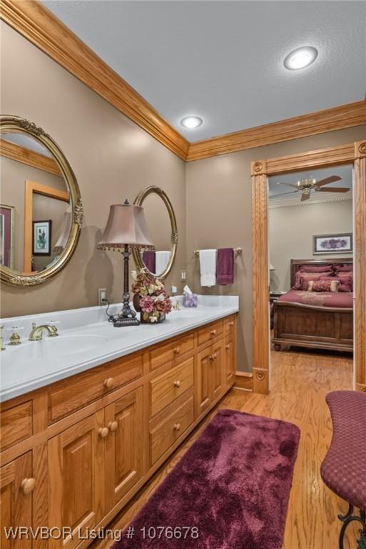 bathroom featuring hardwood / wood-style flooring, vanity, and ornamental molding