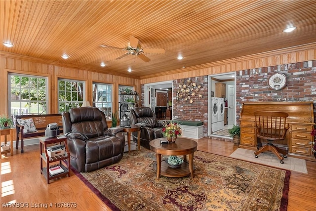 living room featuring light wood-type flooring, washing machine and dryer, ceiling fan, and wooden ceiling