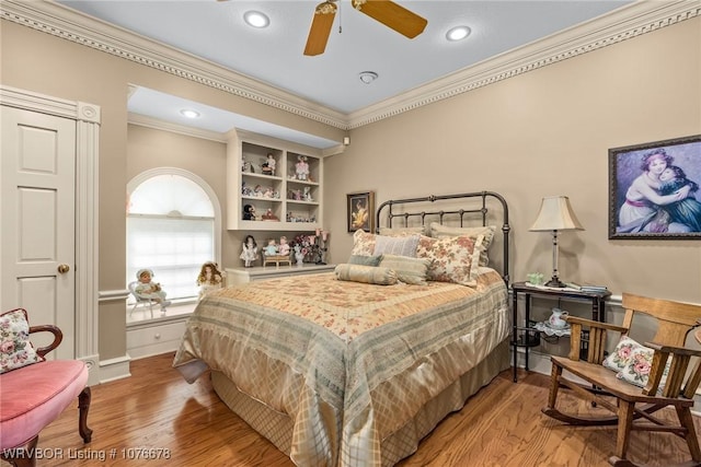 bedroom with hardwood / wood-style floors, ceiling fan, and ornamental molding