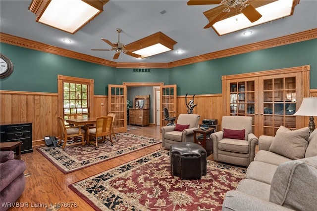 living room featuring french doors, ceiling fan, crown molding, and hardwood / wood-style floors