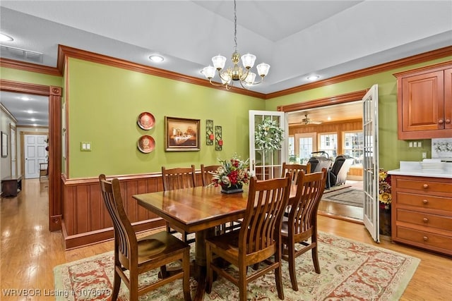 dining area with ornamental molding, ceiling fan with notable chandelier, and light wood-type flooring