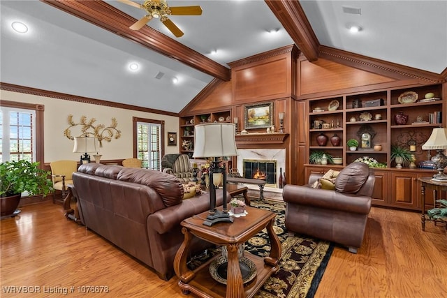 living room with built in shelves, plenty of natural light, and a premium fireplace