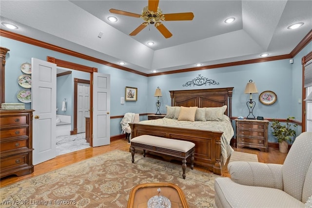 bedroom featuring ceiling fan, light wood-type flooring, crown molding, and a tray ceiling