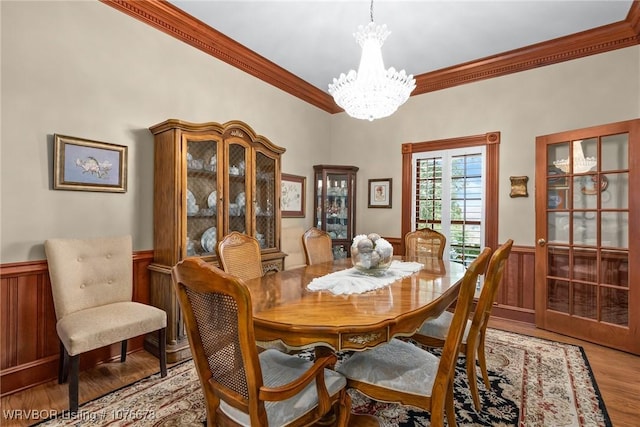 dining area featuring light hardwood / wood-style floors, an inviting chandelier, and crown molding