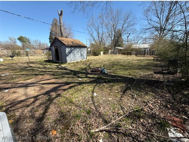 view of yard with fence, an outdoor structure, and a shed