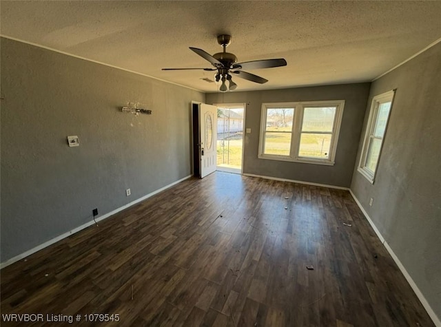 spare room with ceiling fan, baseboards, dark wood-style flooring, and a textured ceiling