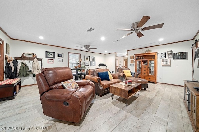 living room featuring ceiling fan, ornamental molding, a textured ceiling, and light hardwood / wood-style flooring