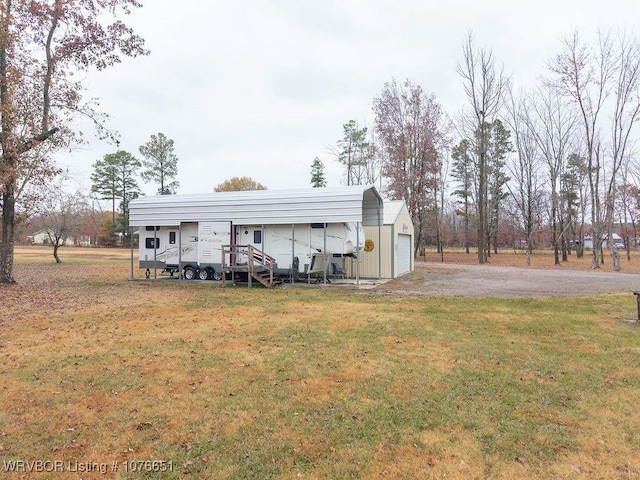 view of outdoor structure with a garage, a yard, and a carport