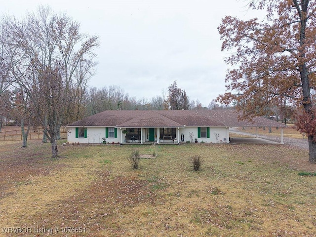 ranch-style house featuring a carport and a front yard