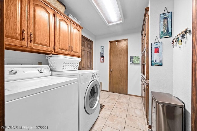 laundry area featuring cabinets, washer and dryer, and light tile patterned floors