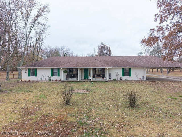 ranch-style house featuring a front lawn and a carport