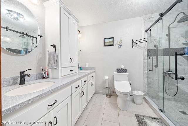 bathroom with walk in shower, tile patterned floors, vanity, and a textured ceiling