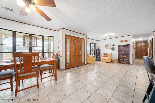 dining room featuring ceiling fan, a healthy amount of sunlight, crown molding, and a textured ceiling