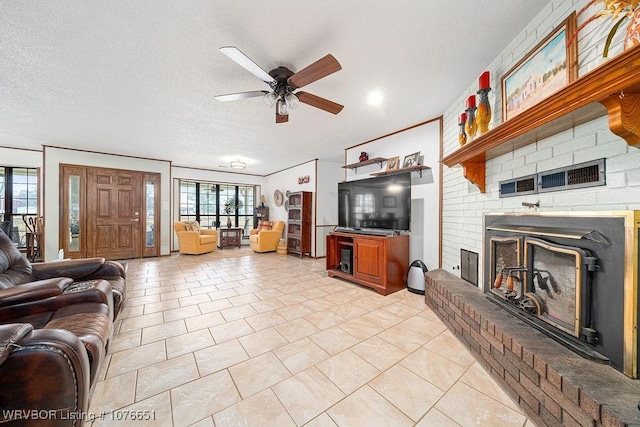 tiled living room featuring crown molding, a brick fireplace, a textured ceiling, and ceiling fan