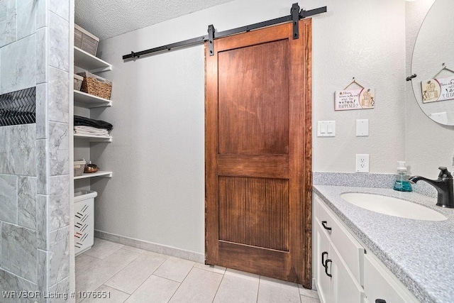 bathroom featuring vanity, tile patterned floors, and a textured ceiling